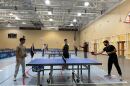 Carolina Pong founder Tripp Roche, middle, watches as table tennis players play at St. Andrews gym in Columbia, S.C. on Dec. 1, 2025.