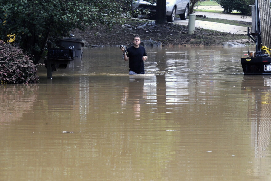 Michael Halbert wades through his flooded neighborhood in Pelham, Ala., on Thursday, Oct. 7, 2021. Parts of Alabama remain under a flash flood watch after a day of high water across the state, with as much as 6 inches of rain covering roads and trapping people.