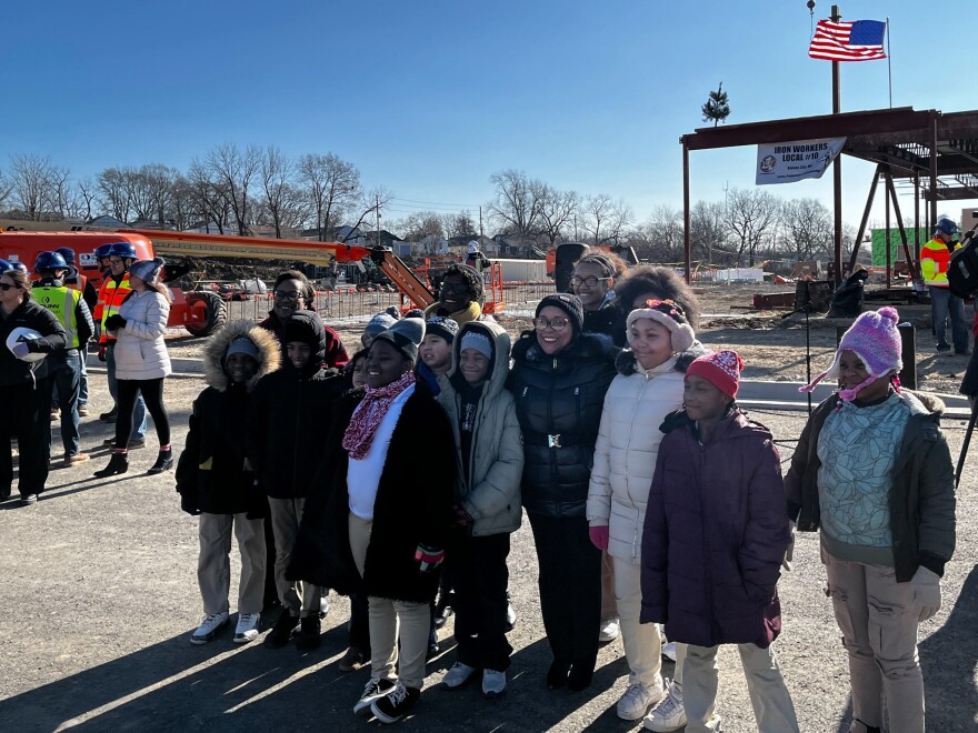 Kansas City Public Schools students pose with superintendent Jennifer Collier ahead of the structure of the new King Empowerment Center.