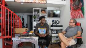 Peterson Guerrier (l) and Pat Greene discuss the Corridor Project Billboard Exhibition at Guerrier's Orlando studio. Photo: Matthew Peddie, WMFE