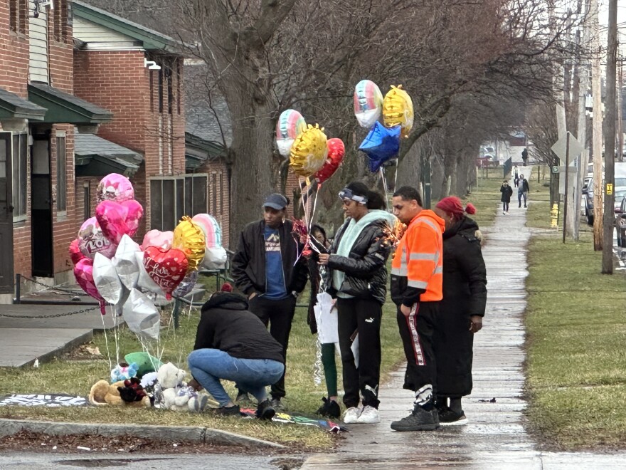  People visit a makeshift memorial for 11-year-old Brexialee Torres-Ortiz, who was shot and killed Monday night on Oakwood Ave. In Syracuse