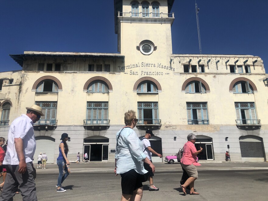 People walk by Terminal Sierra Maestra, a recently refurbished cruise ship terminal on the edge of Havana Harbor.