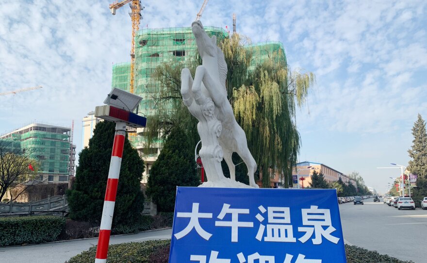 A sign for the Dawu Hot Springs village, under construction, in a thoroughfare in the company town.