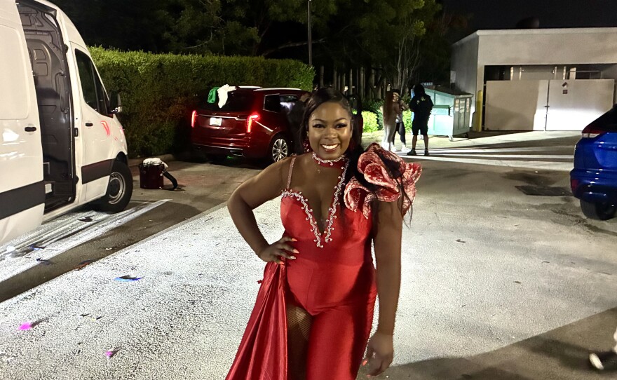 Junkanoo parade leader, Tenova Wright, stands in the parking lot as band members continue to play after the street parade has ended.