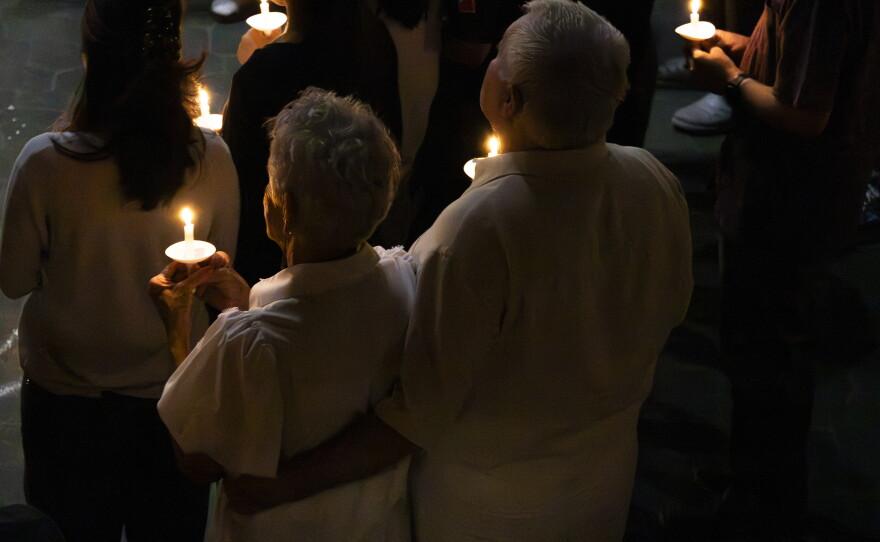 Two attendees sit still in reverence and honor with their candles lit during the candlelight vigil at Hope Lutheran Ministries in Cape Girardeau, Mo, Wednesday, Sept. 9, 2026.