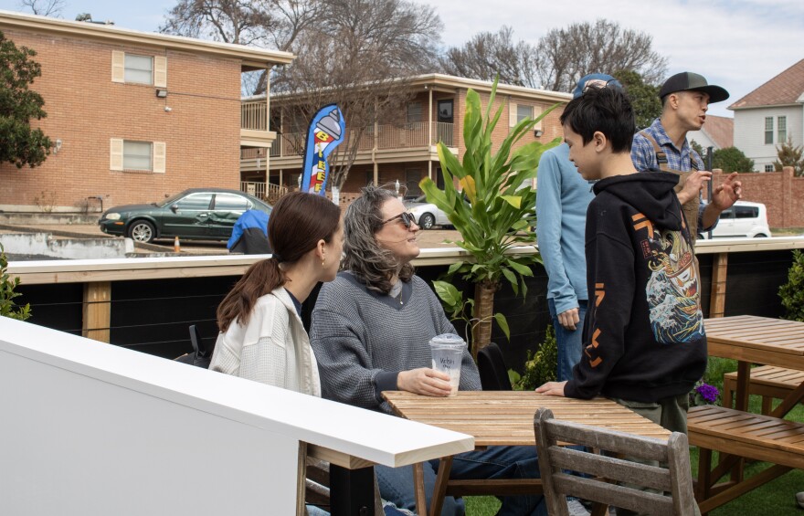 Customers drink their coffee on the newly installed parklet in front of Be Kind Coffee after the ribbon cutting on Saturday, February 21, 2026. The parklet is the first of its kind in Waco.