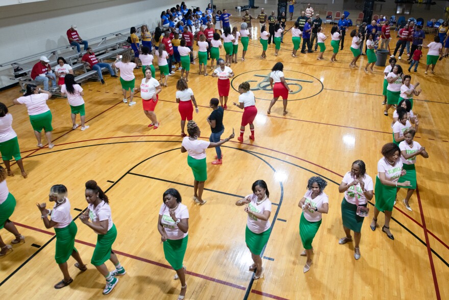 Large group of women in white t-shirts on a basketball court