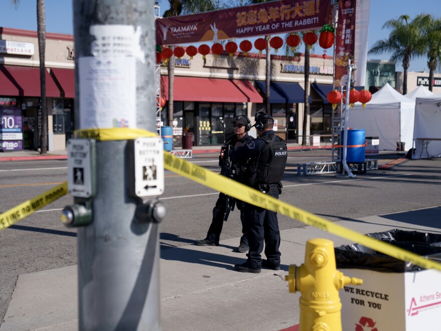 Police officers stand guard near the scene of a deadly shooting on Sunday in Monterey Park, Calif. 10 people were killed and 10 more were injured at a dance studio near a Lunar New Year celebration on Saturday night.