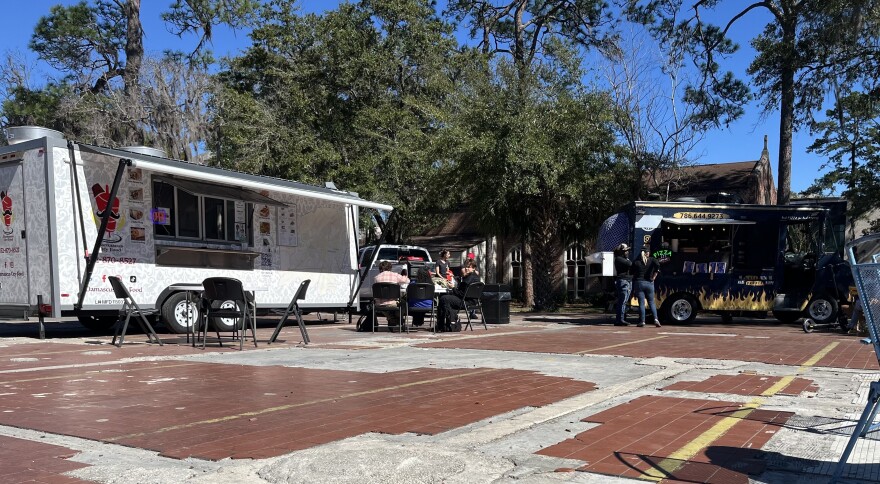 Damascus City Food (left) and Blue Boy Pizza set up and serve customers in the parking lot across from Library West. (Ryan Hirsh/WUFT News)