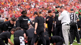 Oregon head coach Dan Lanning, right, stands by as Oregon quarterback Dante Moore is attended to on the field.