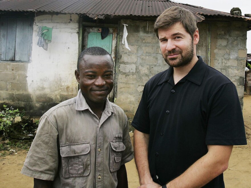 Photojournalist Chris Hondros poses with a a former Liberian government soldier in Monrovia, Liberia, in 2005.