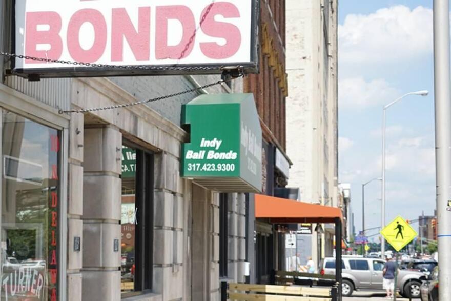 A city street is pictured with signs for businesses that deal in bail bonds. 