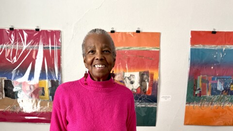 Milwaukee artist, Evelyn Patricia Terry, standing in her home in front of her art
