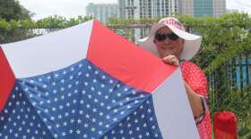 Laureen Vartanian sports a patriotic umbrella to match her equally patriotic outfit, as she waits in line for Trump's re-election rally. Photo by Paola Chinchilla.