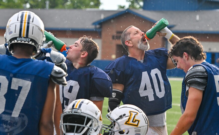 Tom Cillo, 58, and his younger teammates take a break during football practice at Lycoming College.