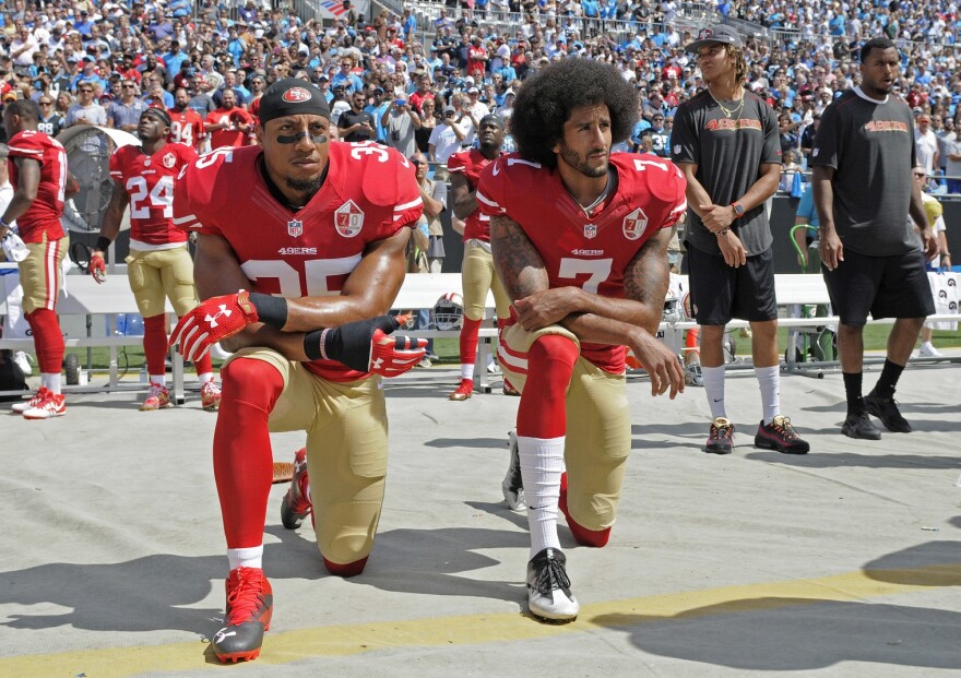 A photo of San Francisco 49ers Colin Kaepernick and Eric Reid kneeling during the national anthem before a game in 2016