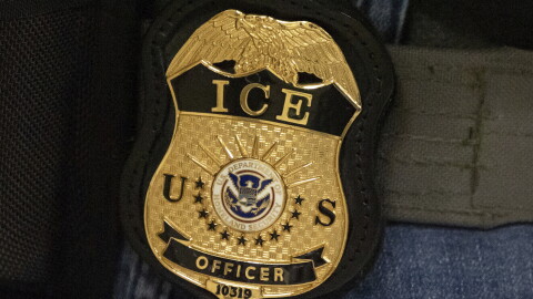 FILE - A federal agent wears an Immigration and Customs Enforcement badge in New York, June 10, 2025. 