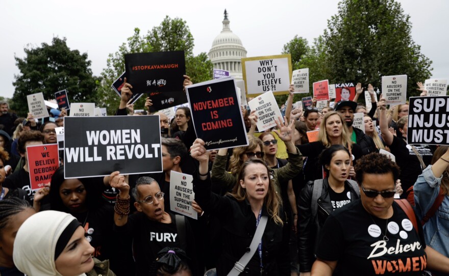 Protesters rally against Supreme Court nominee Brett Kavanaugh as they march near the Capitol.