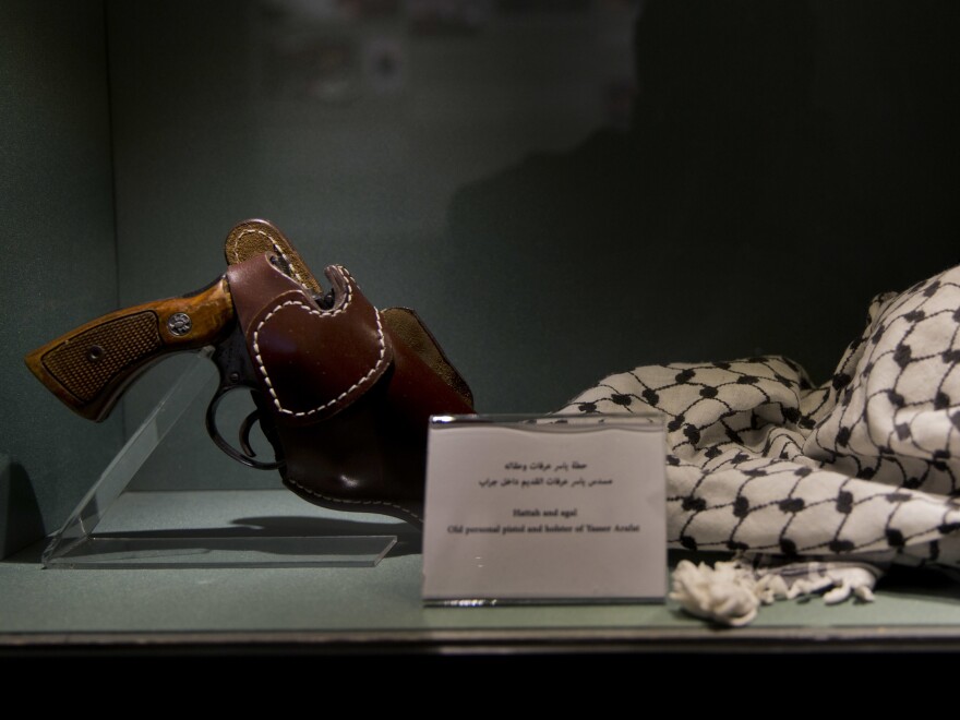 Personal items that belonged to Yasser Arafat, including his pistol and keffiyeh, are displayed in the museum.
