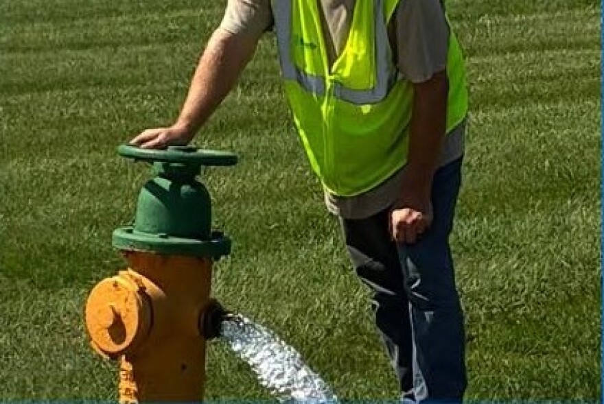 An Evansville Water and Sewer Utility worker opens a fire hydrant to flush the water lines