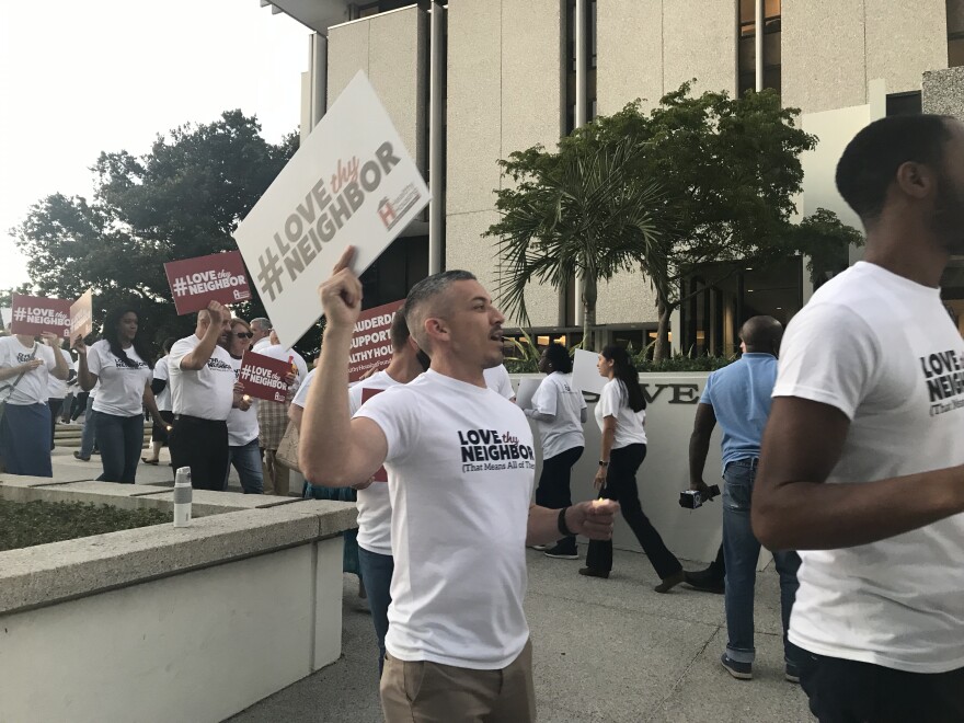 AIDS Healthcare Foundation bussed supporters from its Fort Lauderdale campus to city hall Monday, to rally just before the 6 p.m. community meeting.