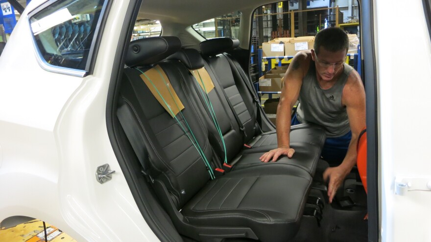 A worker at Ford's assembly plant in Wayne, Mich., installs back seats made from soy-based foam in a Ford C-Max.