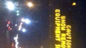 Sign over Highway 169 warns motorists of snow plows ahead.