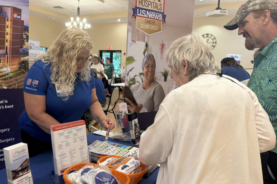 Marsha Mott with UF Health stamps a resident’s bingo card at the Health Fair and Falls Expo tables after educating them on the signs of a stroke.