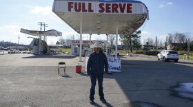 Dave 'Cowboy' Graham stands in front of a damaged gas station in Dawson Springs, Kentucky.