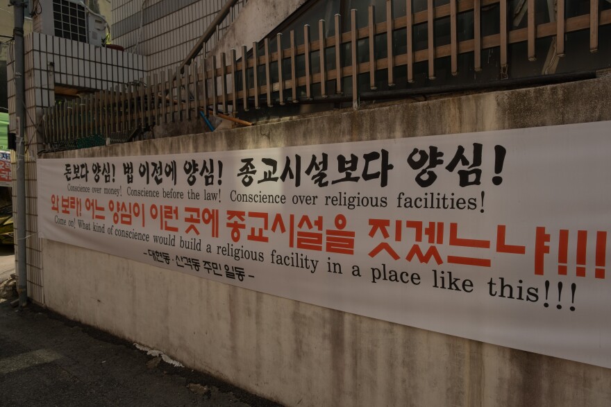 A banner hung in the alleyway across from the Dar ul Emaan Kyungpook Islamic Center.