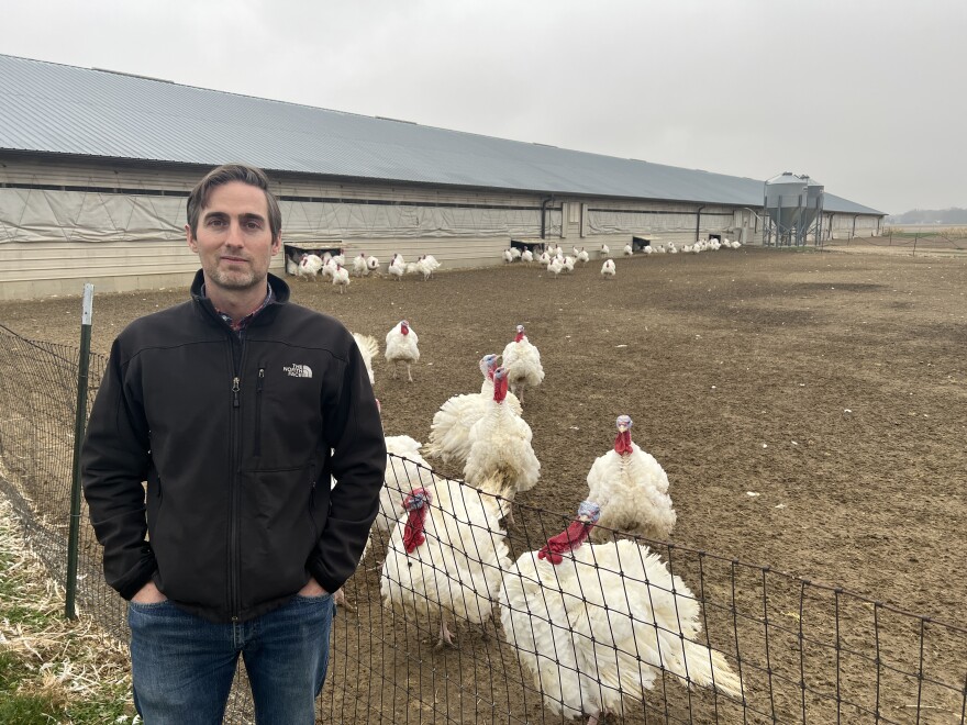 Co-owner of Bowman and Landes, Drew Bowman, stands in front of a rafter of turkeys on their farm