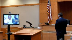 Photo of courtroom with defendant on video conference