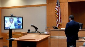 Photo of courtroom with defendant on video conference