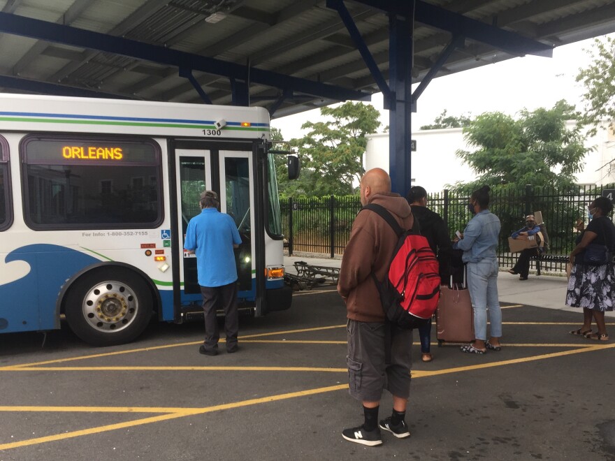 Riders line up at Cape Cod's main bus station in Hyannis to board a bus headed east toward Orleans.