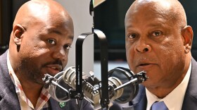  Composite photo of two men facing each other talking at microphones inside a radio studio.