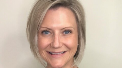 Dr. Kaylin Klie, a woman with short blonde hair, wearing a necklace and a sleeveless black shirt smiles in a photo