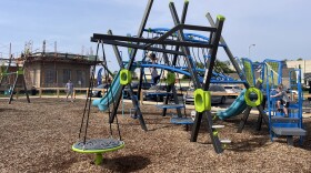 Kids play on the new Davis Park playground in front of the still-in-progress Davis Park community center.