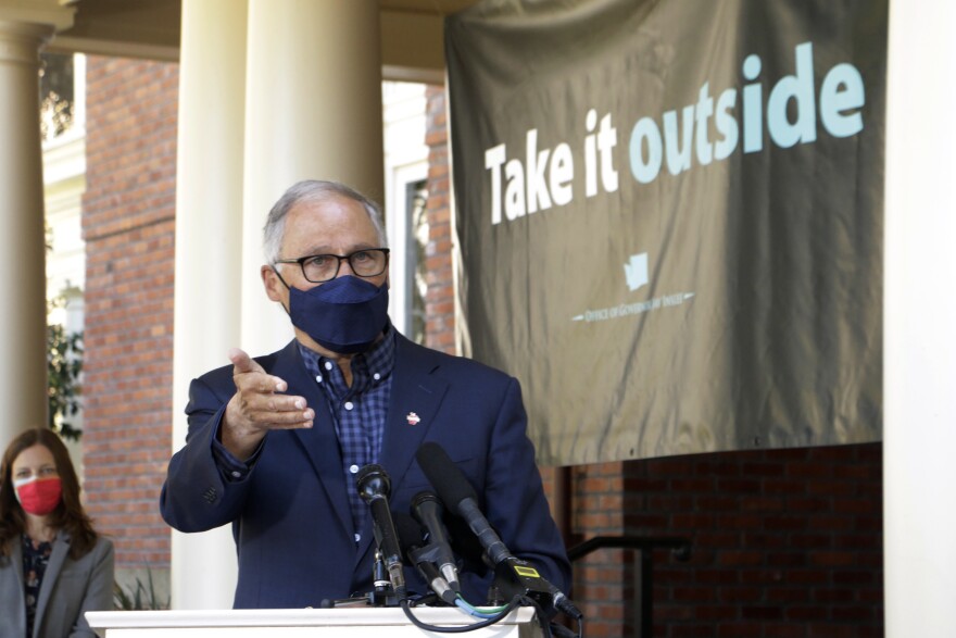 Washington Gov. Jay Inslee speaks to reporters outside the governor's mansion in Olympia on April 15, 2021. Inslee held the outdoor news conference to urge people to get vaccinated and to socialize and conduct business outside as much as possible.