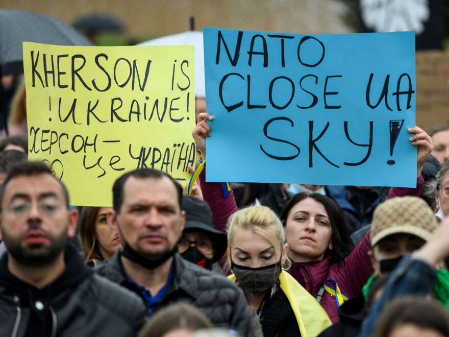 Protestors hold signs reading "Kherson is Ukraine!" and "NATO, close Ukraine's sky" during a demonstration in support of Ukraine in Barcelona.