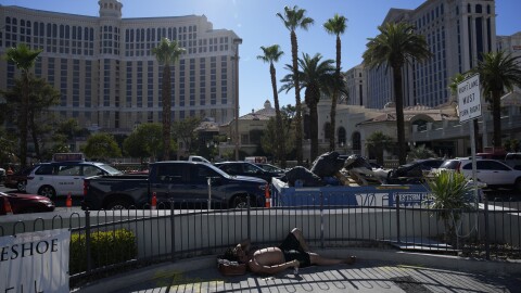 A man lies in partial shade along the Las Vegas Strip in the heat, Thursday, July 13, 2023, in Las Vegas. Even desert residents accustomed to scorching summers are feeling the grip of an extreme heat wave smacking the Southwest this week. Arizona, Nevada, New Mexico and Southern California are getting hit with 100-degree-plus temps and excessive heat warnings. (AP Photo/John Locher)