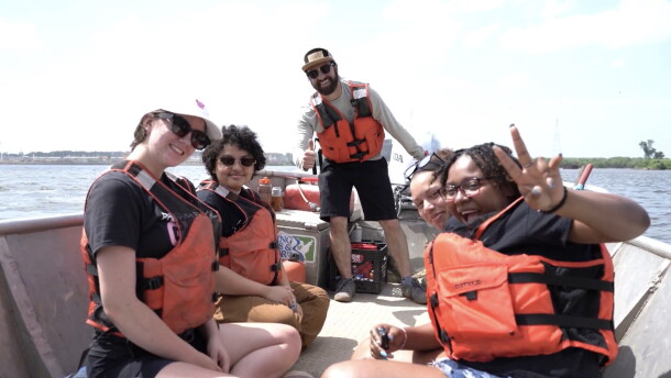 Her Voice Media fellows Abigail Hauser, Satara Masengarb, Kia Sykes, and Tamiah Rogers learn about Mississippi River pollution on the water with Living Lands & Waters vice president Dan Breidenstein, for the documentary, "If the River Were a Woman."