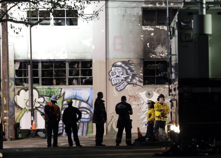 Emergency personnel stage in front of the site of a warehouse fire that started Friday night and killed dozens, Sunday, Dec. 4, 2016, in Oakland, Calif. (Marcio Jose Sanchez/AP)