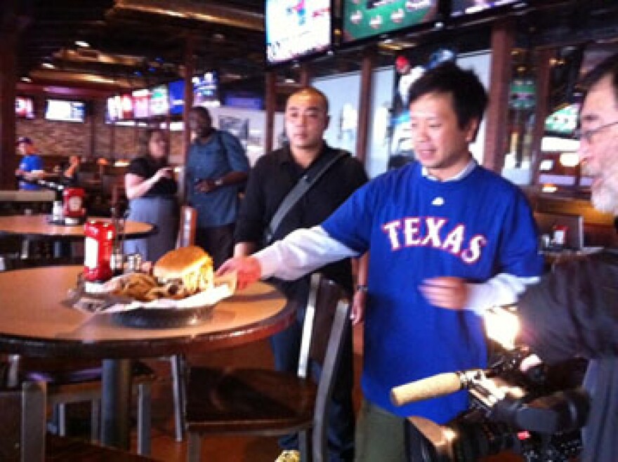 A team from Tokyo Broadcasting inspects a Darvicious burger at BoomerJacks in Arlington.