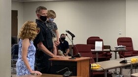 Bloomington Interim Police Chief Greg Scott stands with his wife and grandson, while he speaks at the Bloomington City Council meeting, Aug. 23, 2021, at the downtown Government Center.  Scott is retiring Sept. 3. Officials expect to name the next chief later this week.