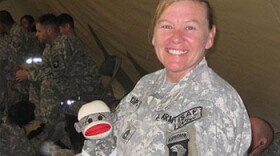 Sgt. 1st Class Candace Chapman poses with her stuffed sock monkey while overseas.