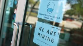 A 'we are hiring' sign in front of a store in Miami, Florida.