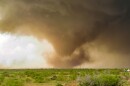 A tornado touches down in a grassy field beside a dirt road. Storm chaser Quincy Vagell captured this image during a tornado on May 23, 2024 in Eldorado, Oklahoma. Vagell has been storm chasing since 2014.