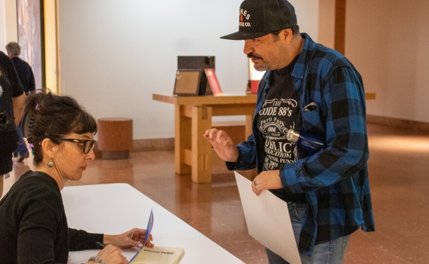 López signing a guests book.