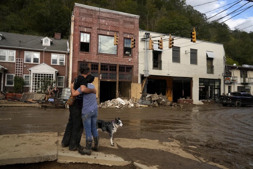 Resident Anne Schneider, right, hugs her friend Eddy Sampson as they survey damage caused by Hurricane Helene, Oct. 1, 2024, in Marshall, N.C.