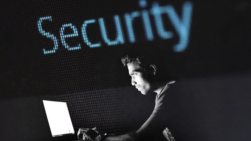 A man working on a laptop with the word "Security" above him.